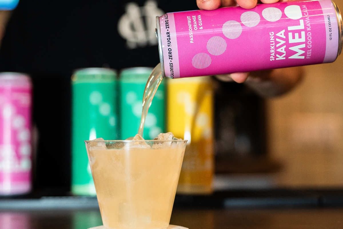 Kava root beside cans of Melo