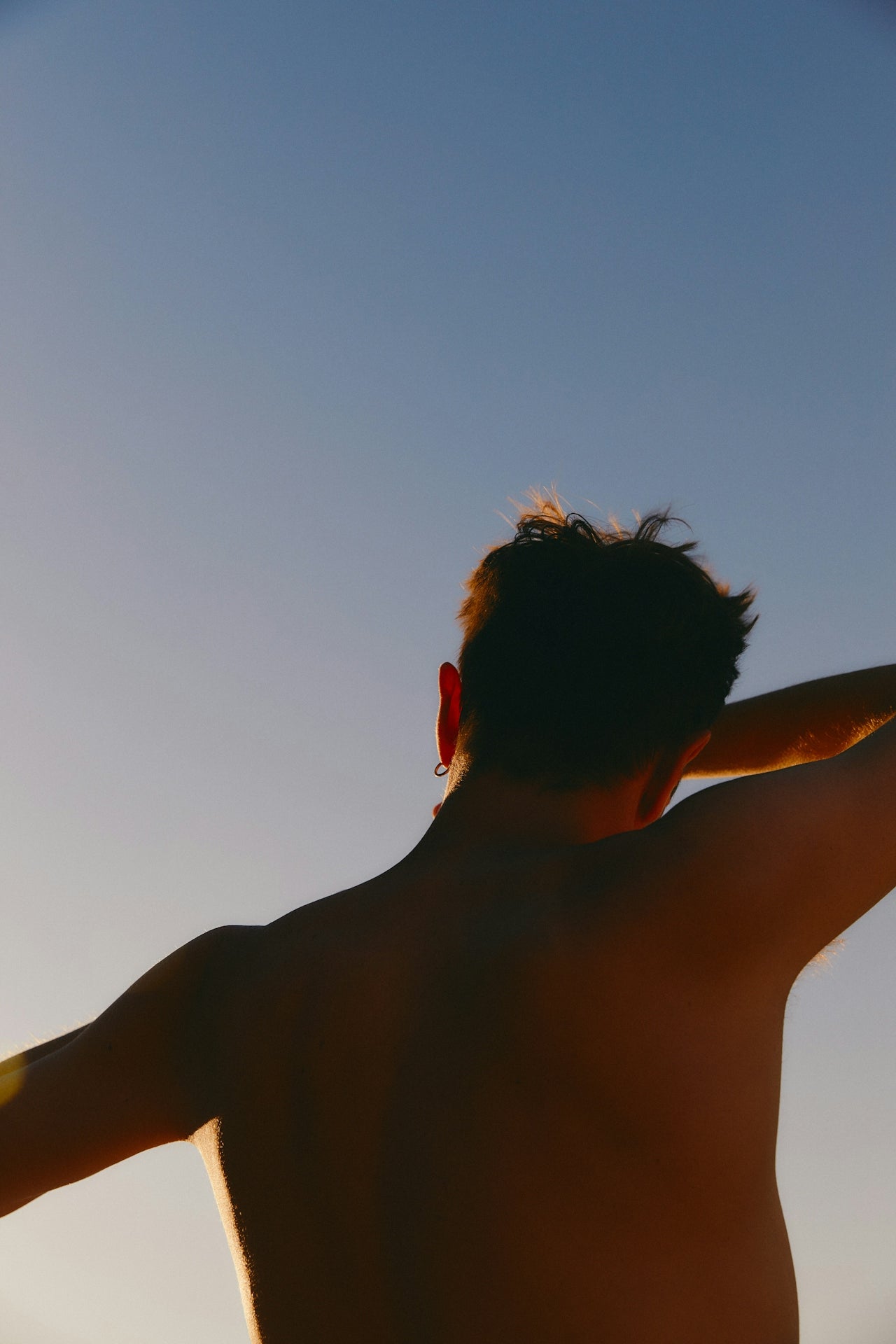 Silhouette of a person against a clear blue sky