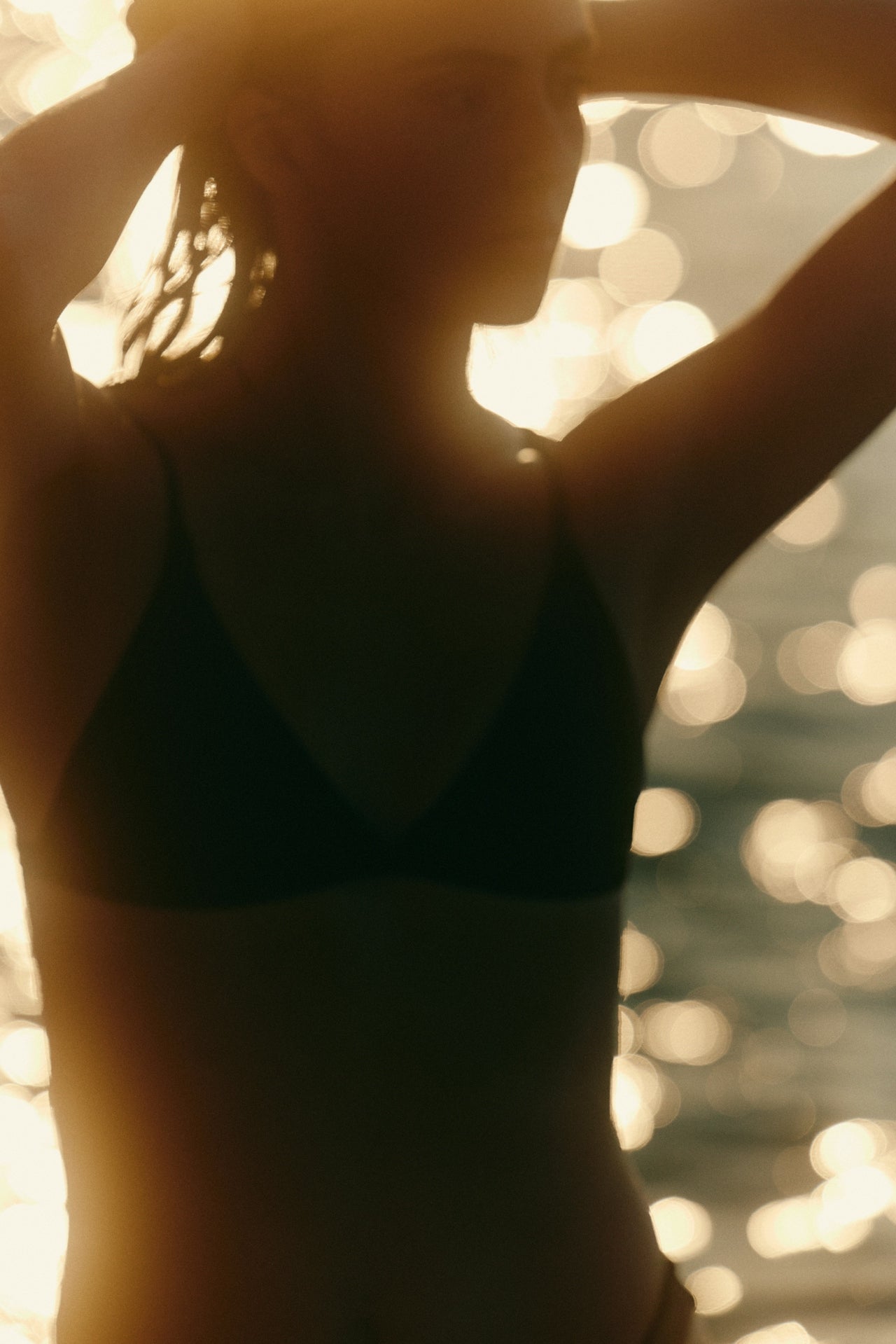 Silhouette of a person against a blurred, glowing light background
