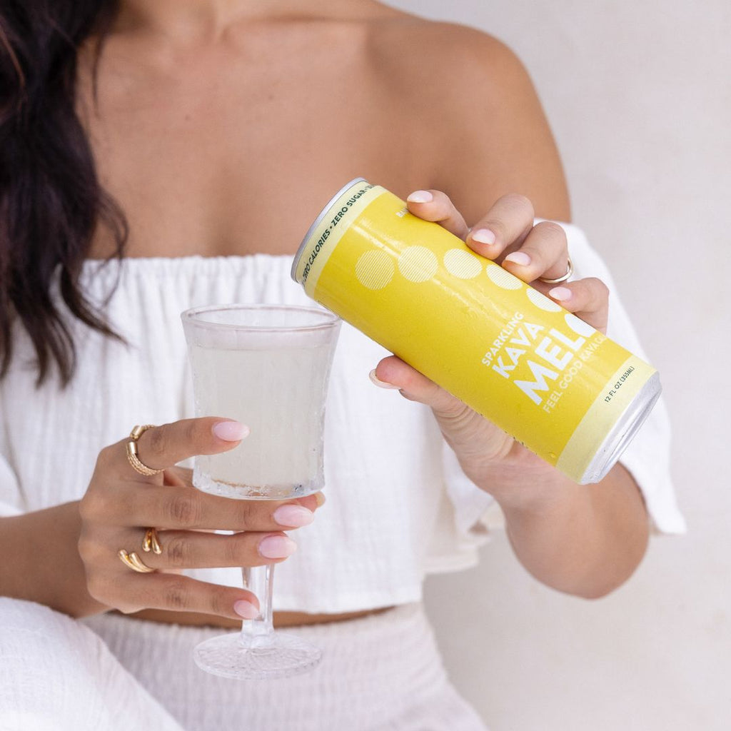 Person holding a yellow can and a glass with a white background